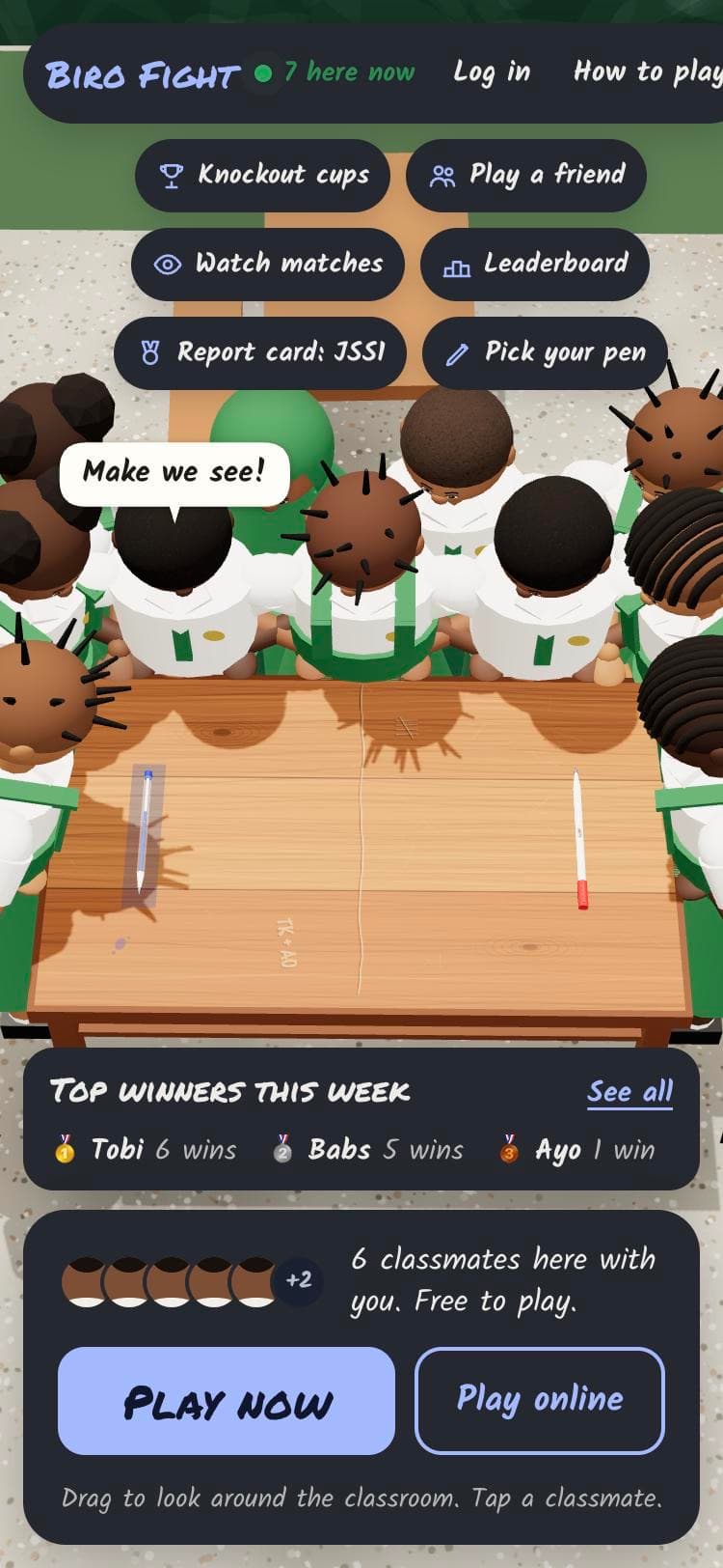 Classmates crowded round a desk for a biro fight
